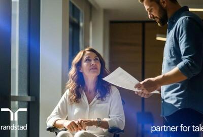 Una mujer en silla de ruedas conversa con un hombre en una oficina profesional. Generado por IA.  Una mujer en silla de ruedas conversa con un hombre en una oficina profesional. Generado por IA.