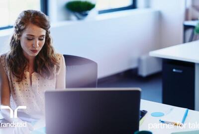 Mujer sentada en un escritorio detrás de una computadora   Mujer sentada en un escritorio detrás de una computadora